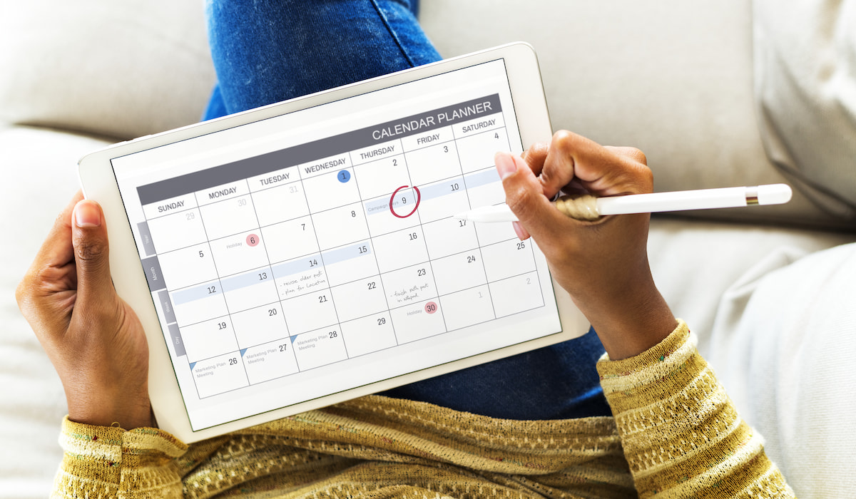 Woman checking calendar planner on digital tablet