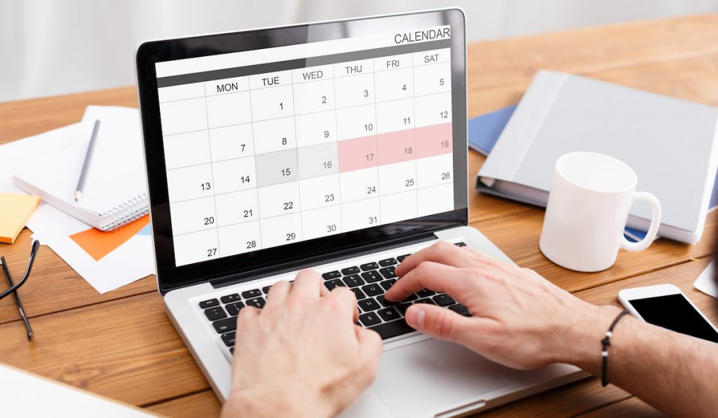 Man Working With Calendar Planner On Laptop