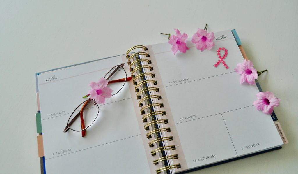 Overhead shot of a daily planner with glasses and flowers 