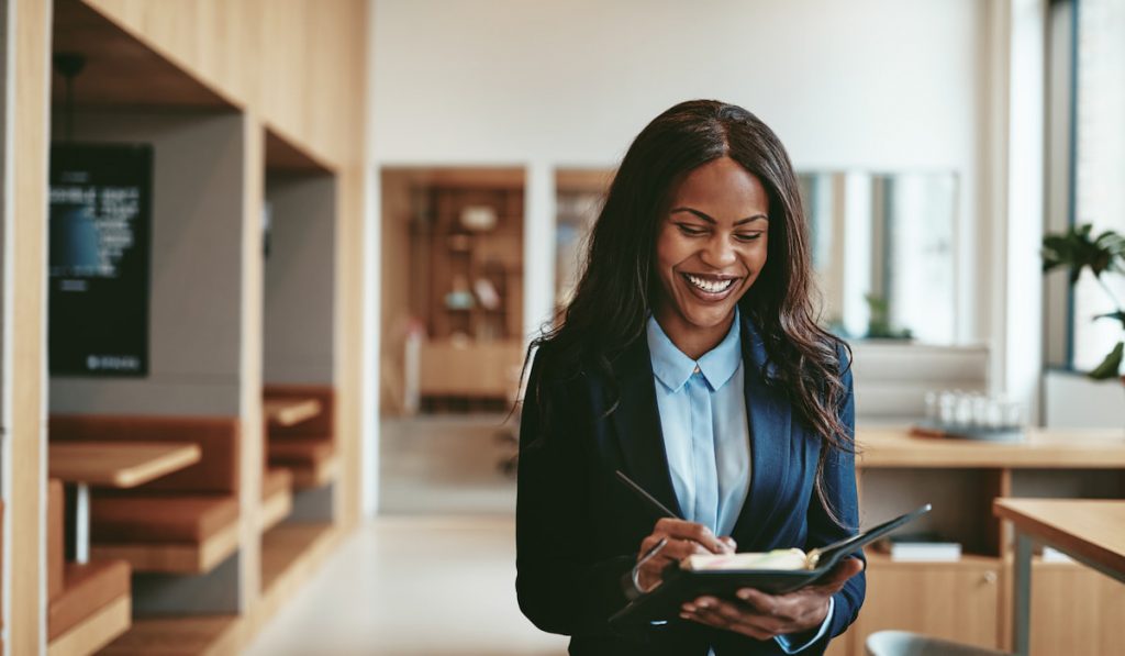 businesswoman walking in the office writing notes