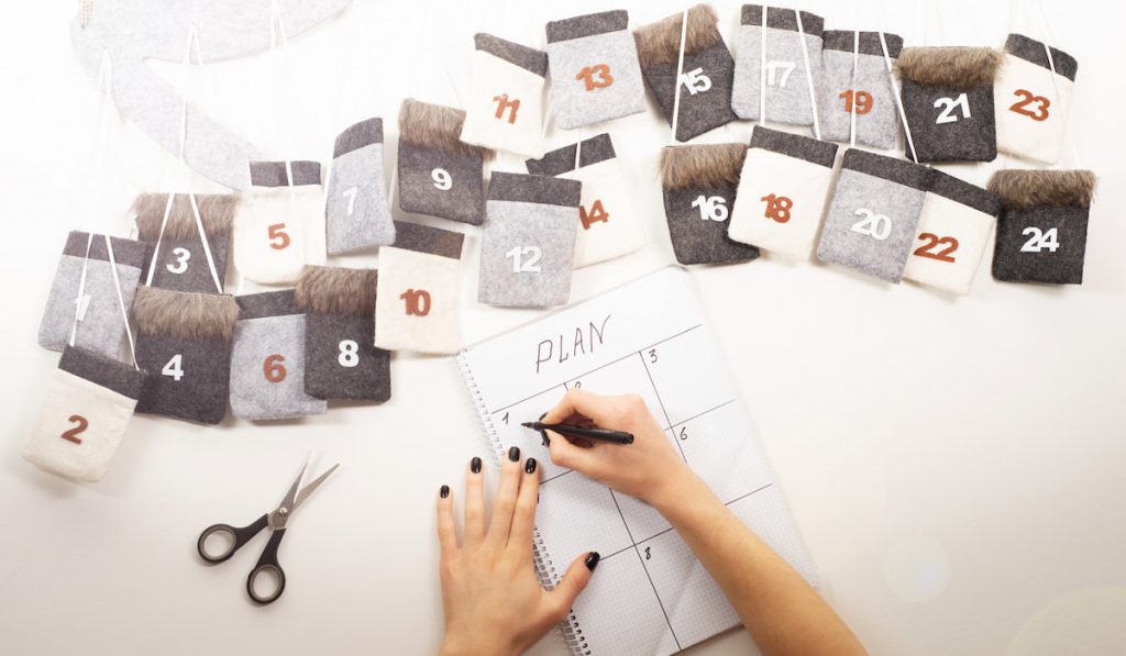 homemade wall calendar and hand writing on a paper in columns for plan