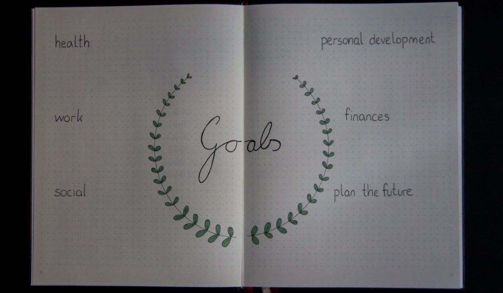 A simple goal written in personal bullet journal on black background