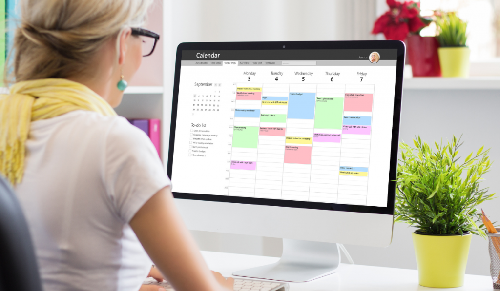 Woman using calendar app on computer in office
